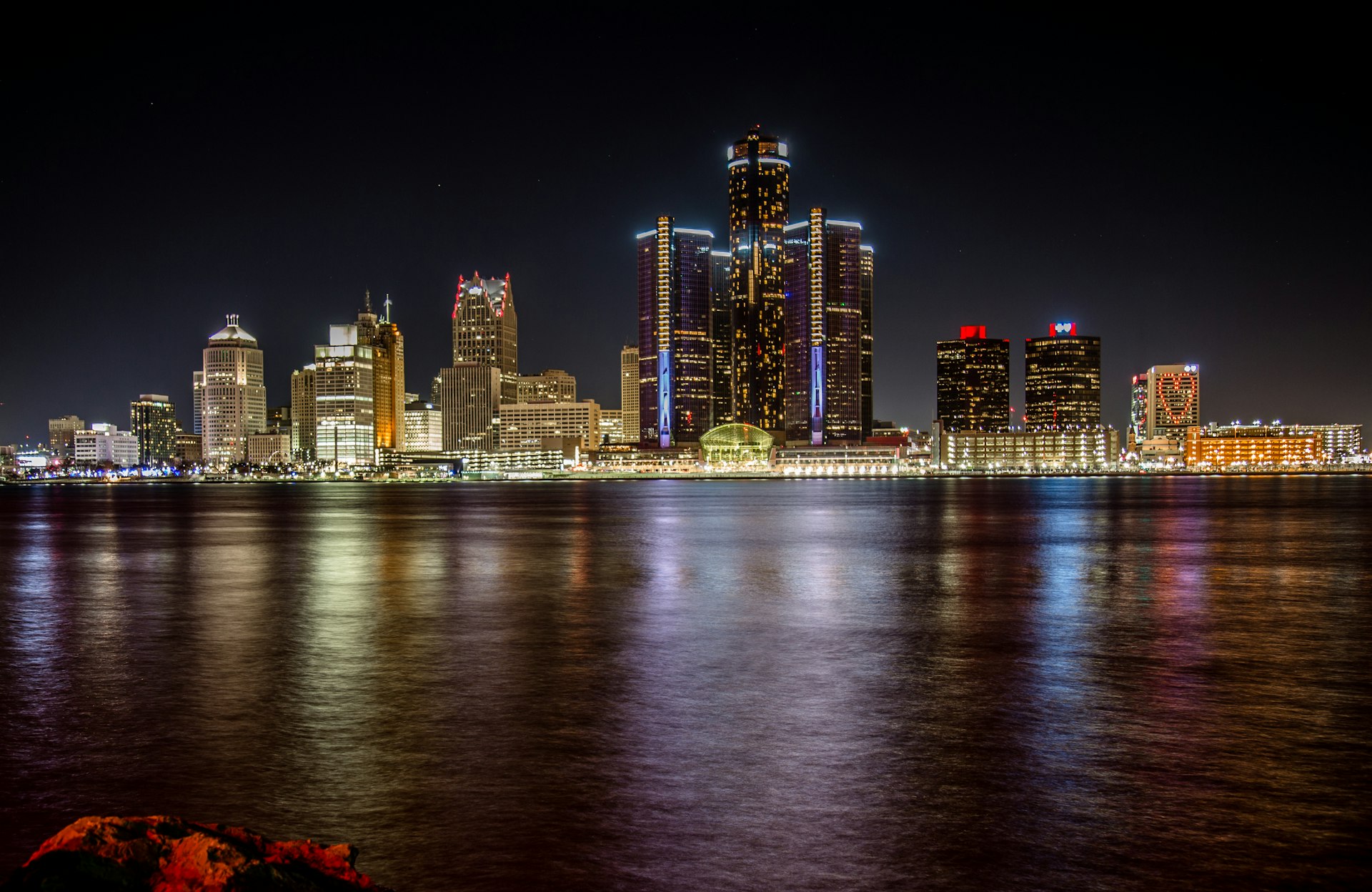 Detroit skyline at night with lights reflecting on the Detroit River