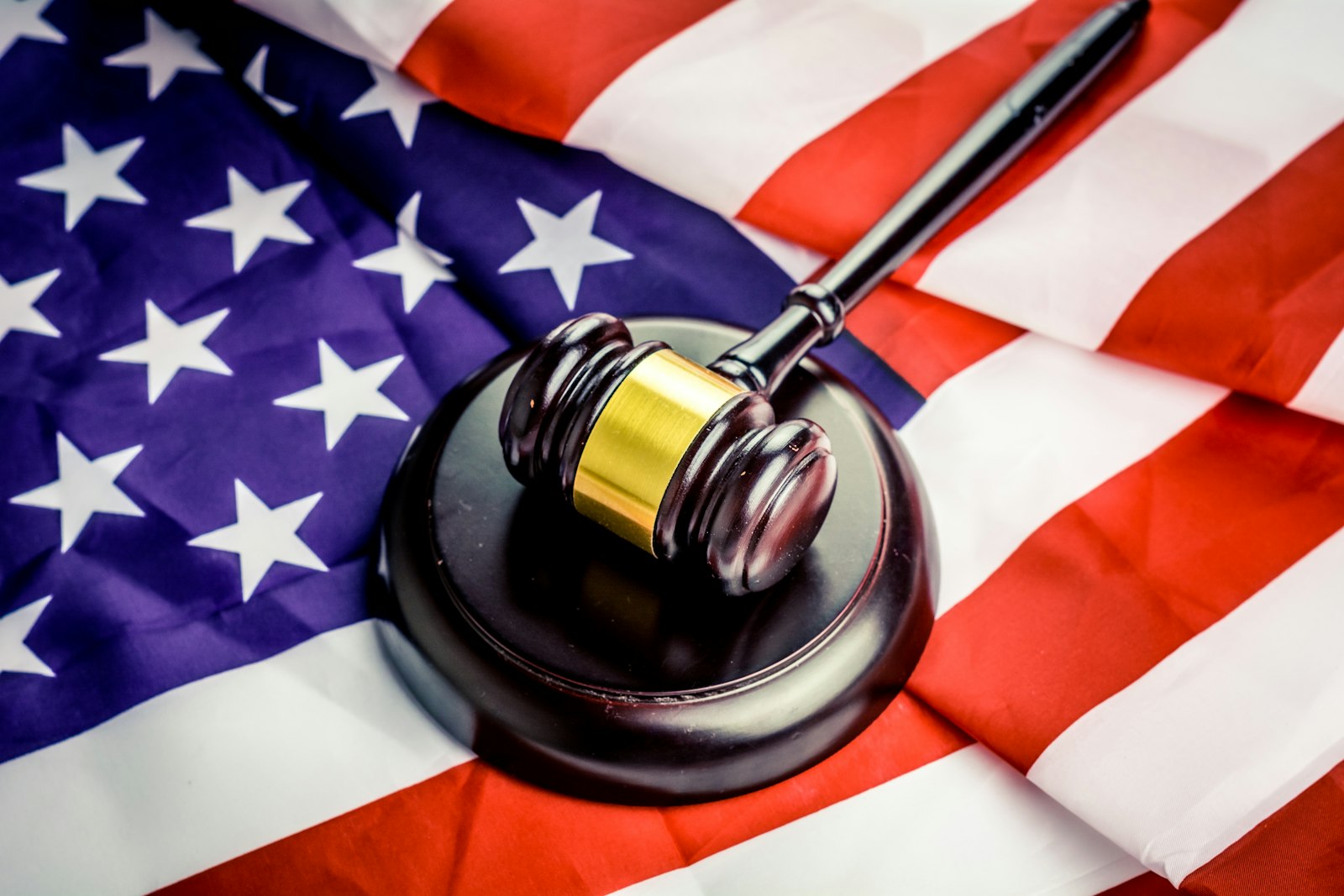 Judge's gavel and sound block resting on a US flag